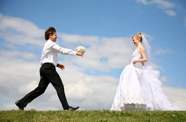 Snoubenec nese nevěstě kytici — Stock fotografie