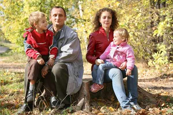 Madre con la hija y el abuelo se sientan en el parque en otoño — Foto de Stock