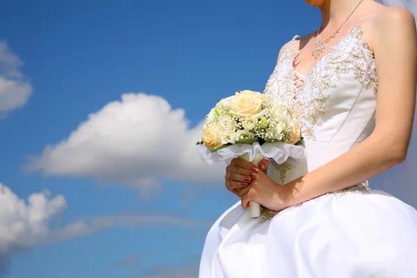 Bruden rymmer bukett mot bakgrund av himlen — Stockfoto
