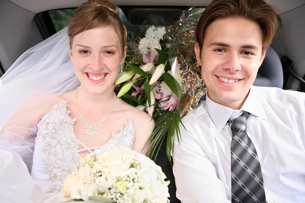 Nevěsty a snoubence v automobilu — Stock fotografie