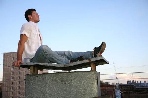 Man sits on the roof — Stock Photo, Image