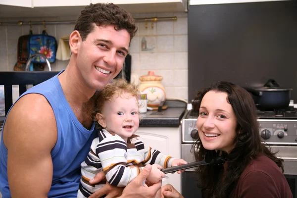 Sorridendo padre, madre e bambino in cucina — Foto Stock