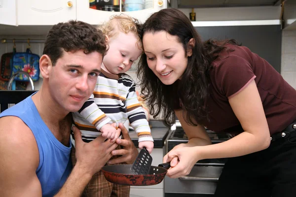 Pai, mãe, criança e frigideira na cozinha — Fotografia de Stock