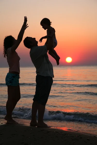 Maman avec sa fille et son grand-père au coucher du soleil en mer — Photo