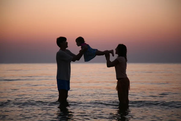 Семья в море на закате — стоковое фото