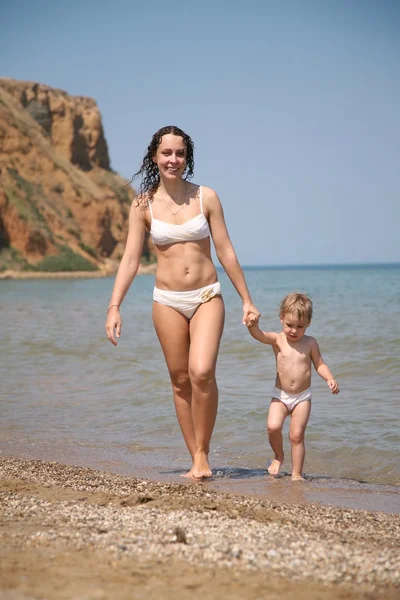 Молода жінка з дитиною на березі моря — стокове фото