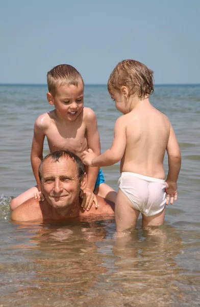 Homem com crianças no mar — Fotografia de Stock