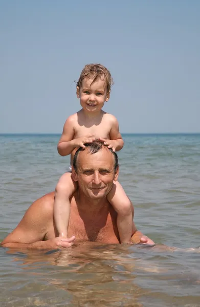 Человек с ребенком в море — стоковое фото