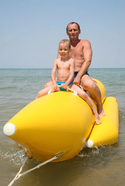 Grandfather with the grandson they sit on the inflatable boat — Stock Photo, Image