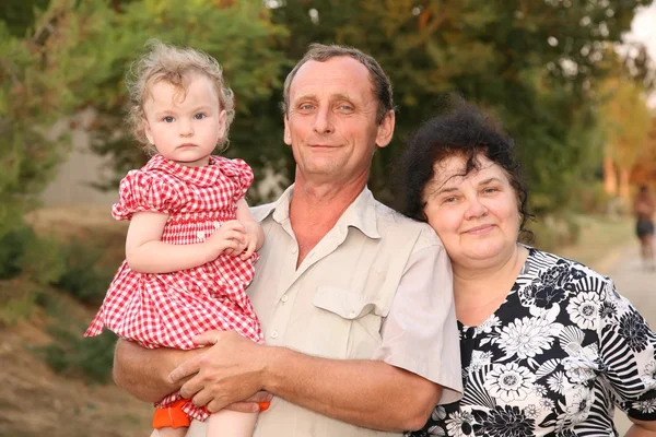 Grootvader met kleindochter op handen en door grootmoeder — Stockfoto
