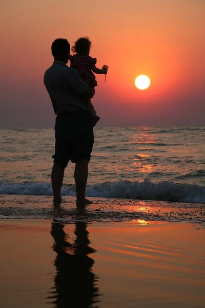 Großvater mit Kind vor dem Hintergrund des Sonnenuntergangs auf See im Wasser — Stockfoto