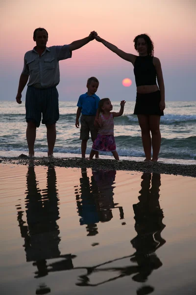 Mère avec enfants et grand-père à terre au coucher du soleil — Photo