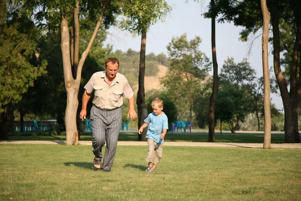 Dziadek z wnukiem uruchomić, trawnik — Zdjęcie stockowe
