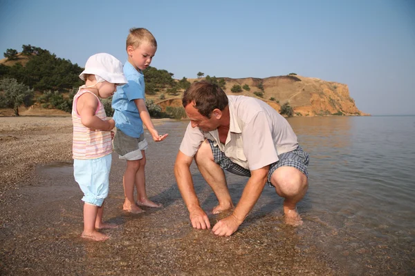 Abuelo con nietos en la playa —  Fotos de Stock