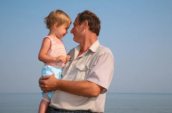 Grootvader houdt kleindochter op handen — Stockfoto