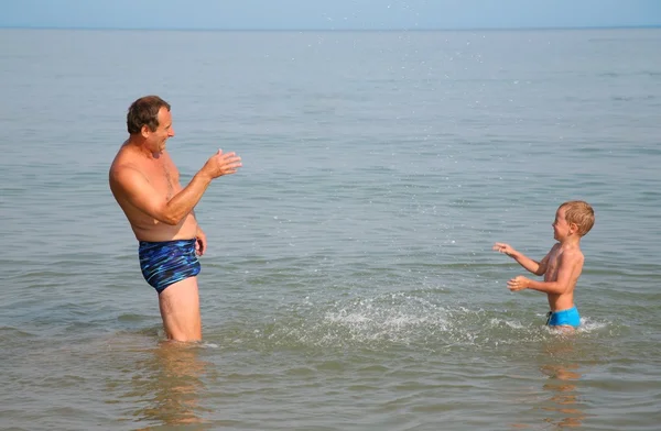 Grandfather with grandson sprinkle by water friend on friend — Stock Photo, Image