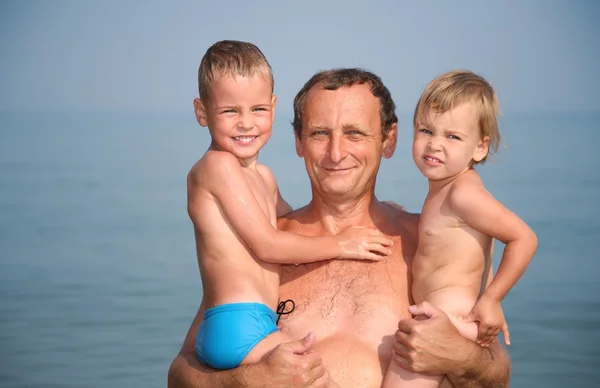 Grandfather holds grandsons on hands — Stock Photo, Image