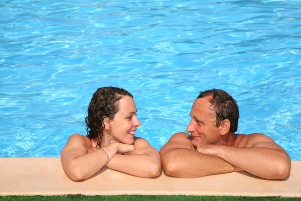 Donna e uomo al bordo piscina — Foto Stock