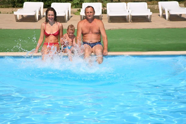 Donna con bambino e uomo sedile bordo piscina — Foto Stock