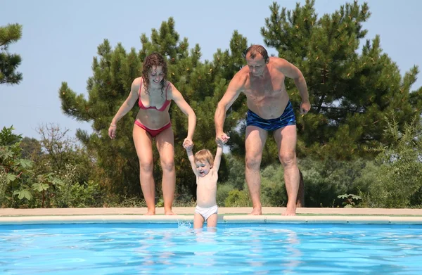 Γυναίκα και άντρας παραλείψετε παιδί στην πισίνα — Φωτογραφία Αρχείου