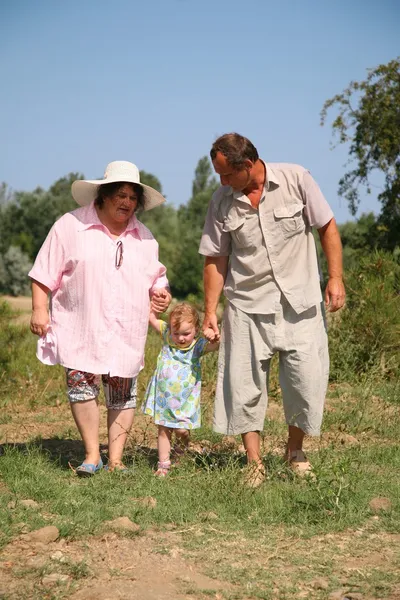 Elderly pair goes for a walk with the granddaughter — Stock Photo, Image