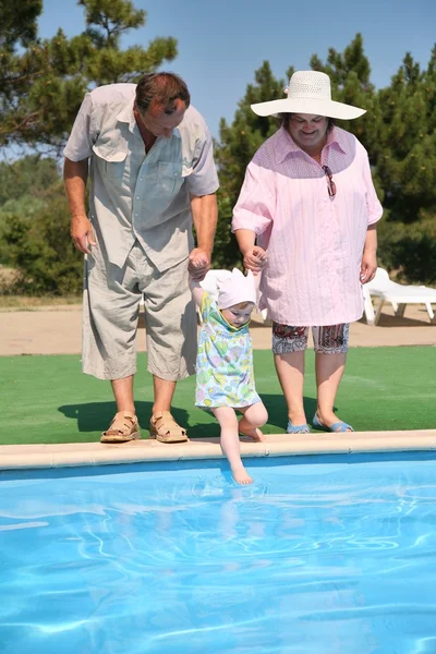 Coppia anziana con la nipote a parte della piscina — Foto Stock
