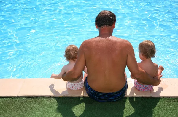 Grandfather with granddaughters seats aboard of pool — Stock Photo, Image