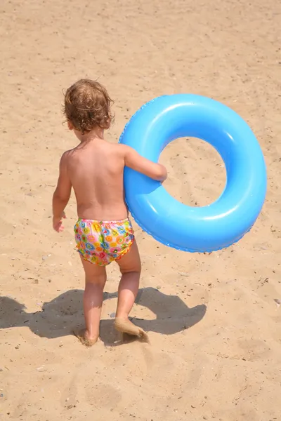 那个女孩与一个救生圈圆环就在沙滩上 — 图库照片