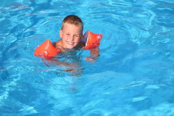 Le garçon flotte dans la piscine — Photo