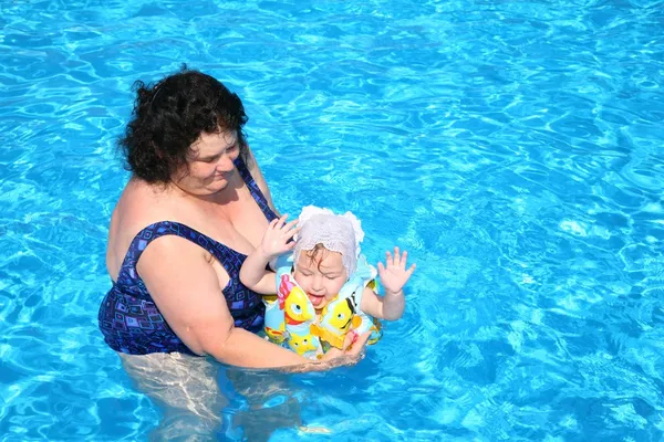 A avó brinca com a neta na piscina — Fotografia de Stock