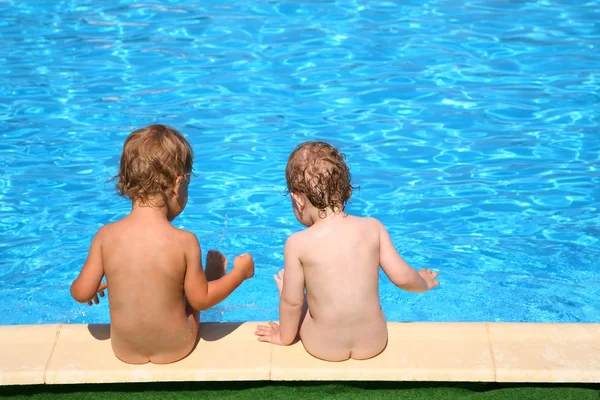 Deux enfants s'assoient à la piscine — Photo