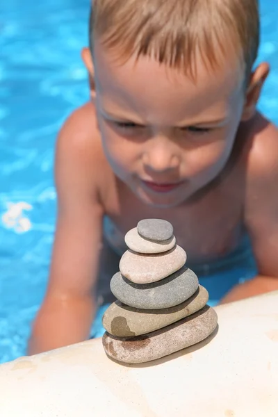 De jongen kijkt naar een figuur van stenen — Stok fotoğraf