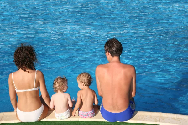 Pais e filhos sentam-se na piscina — Fotografia de Stock