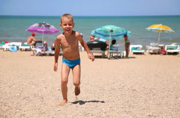 Il ragazzo corre su una spiaggia . — Foto Stock