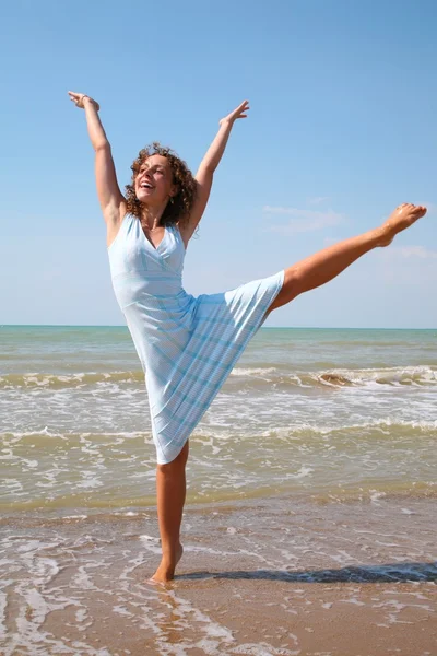 Νεαρή γυναίκα κάνει άσκηση στην άκρη της θάλασσας — Φωτογραφία Αρχείου