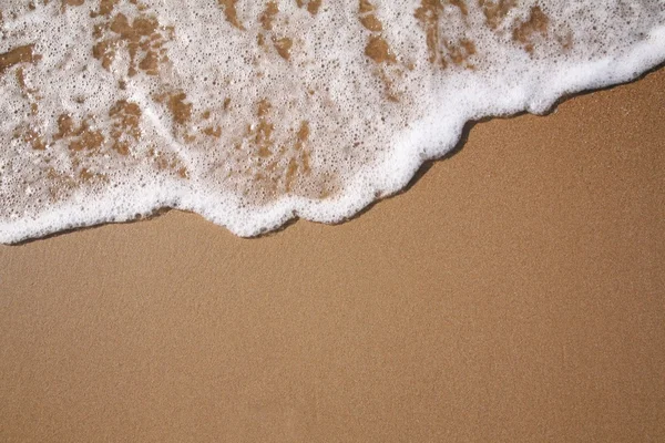 Schuim op zand — Stockfoto