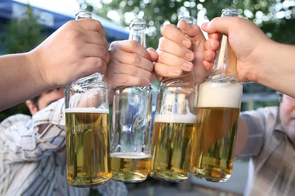 Four hands with the bottles of the beer — Stock Photo, Image