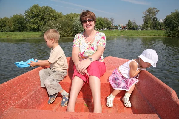 Женщина с детьми в лодке — стоковое фото