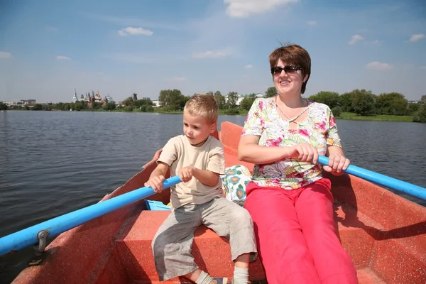 Жінка і хлопчик у човні з веслами — стокове фото