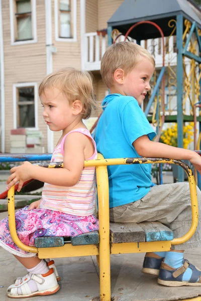 Hádky chlapec a dívka sedí na lavičce — Stock fotografie