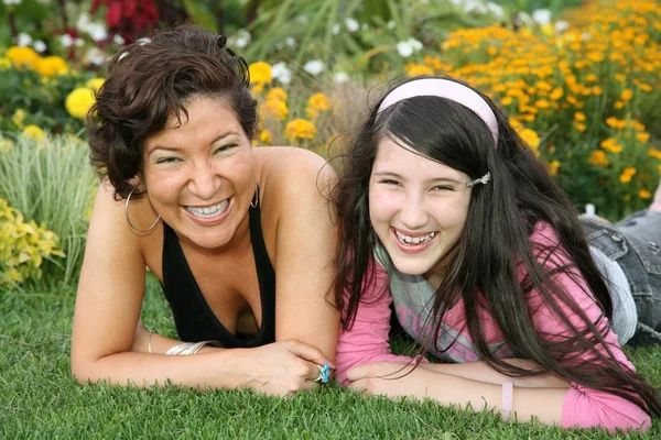 Mamma med dotter ligger på gräs — Stockfoto