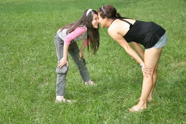 Madre e hija de pie sobre la hierba — Foto de Stock