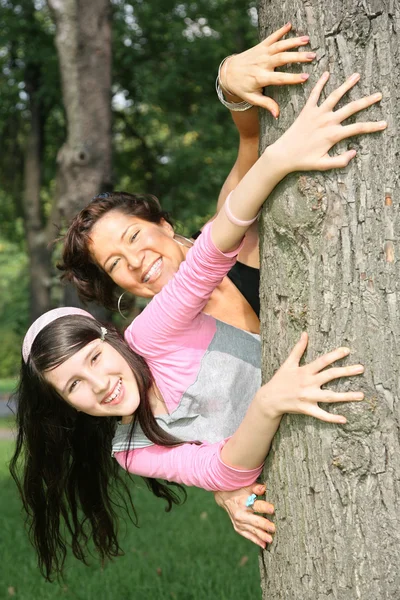 Madre e hija para ser sostenidas por el árbol —  Fotos de Stock