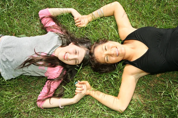 Mother and daughter lie on the grass — Stock Photo, Image