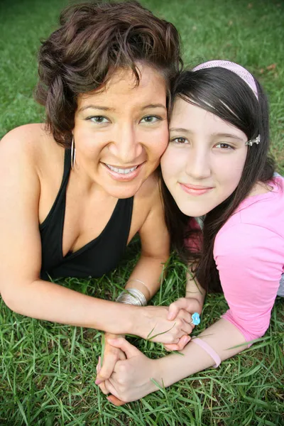 Woman and teenager lie on the grass — Stock Photo, Image
