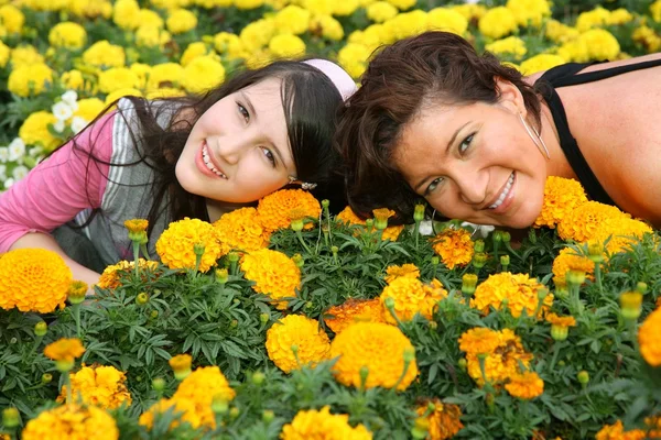 Mother and daughter lie among flowers — Stock Photo, Image
