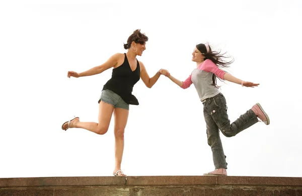 Mother and daughter dance on the rock wall — Stock Photo, Image