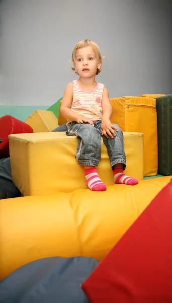 Дівчина сидить на жовтому кубі — стокове фото
