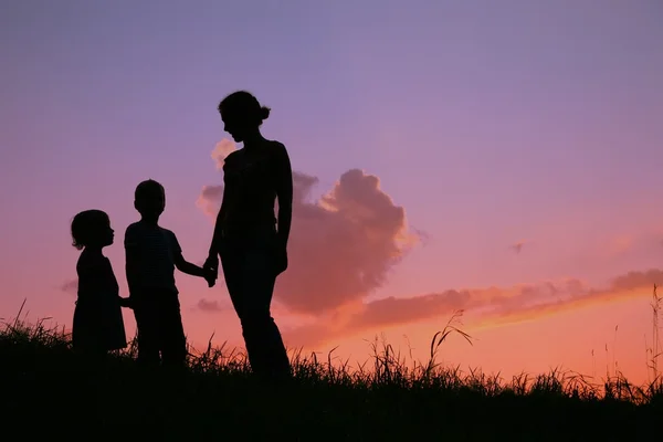 Çocuklar günbatımı annesiyle siluet — Stok fotoğraf