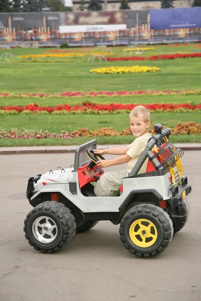 Хлопчик в іграшковій машині в парку — стокове фото